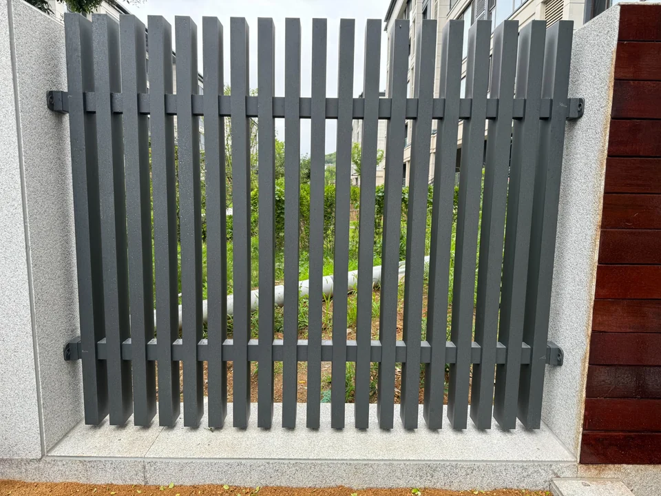 Grey vertical fence blades with rails and fixing brackets visible from the rear
