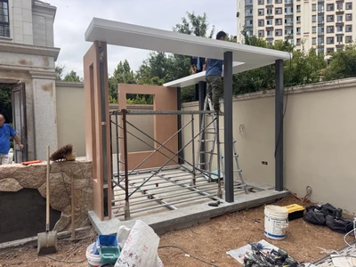 An outdoor structure during on-site assembly with scaffold and unfinished work visible.